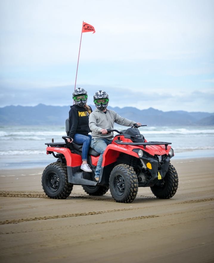 Two women sitting on an ATV at Pismo Beach
