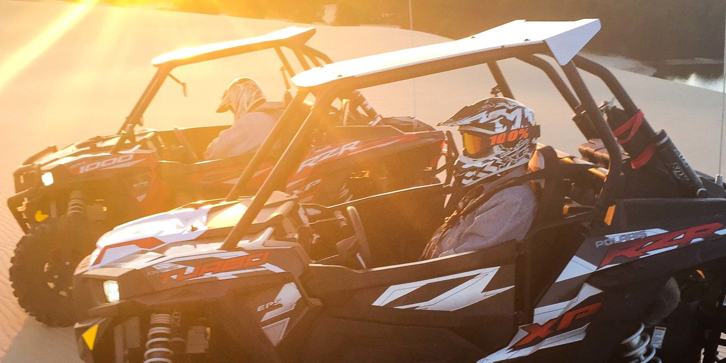 Two guests riding in Can Am Maverick Turbo at sunset