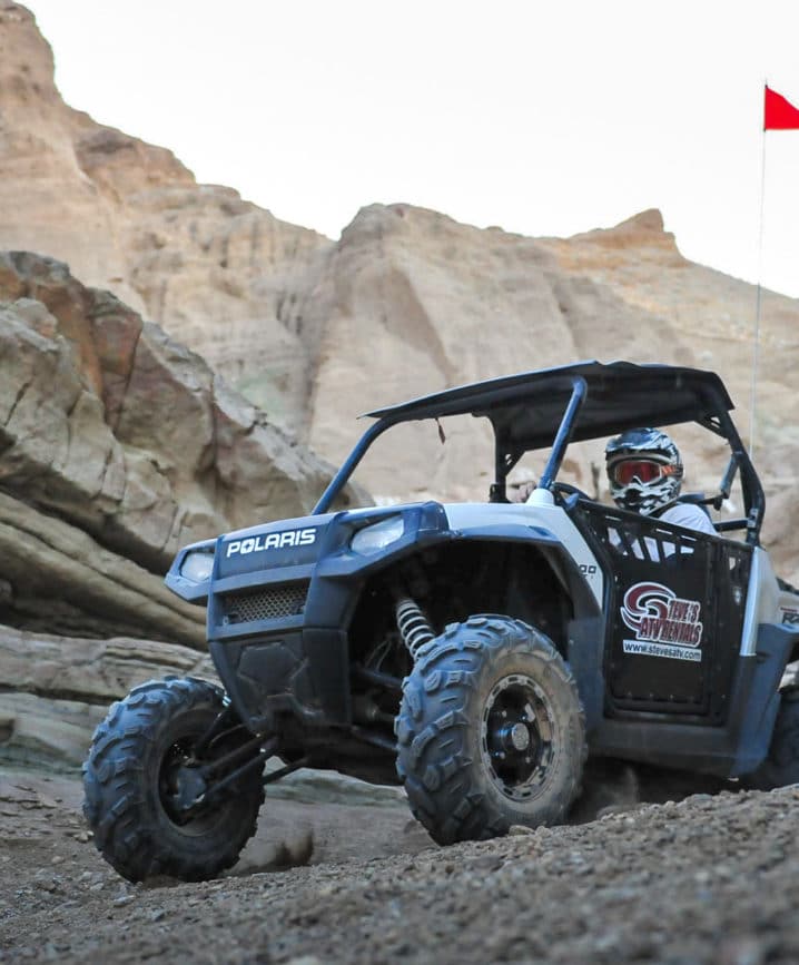Guest riding ATV in rocky terrain