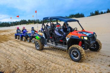 Family riding on different colored ATVs in Oregon
