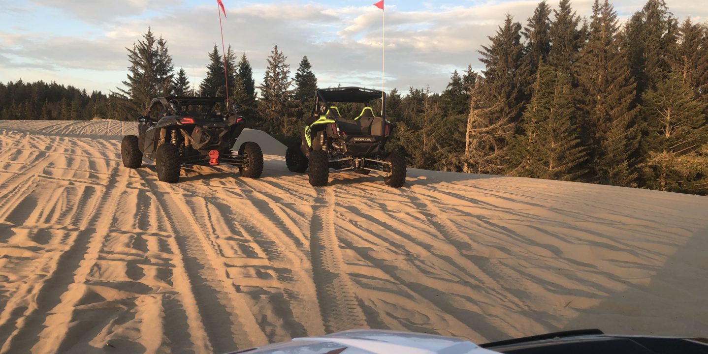 atvs making tracks in sand dune