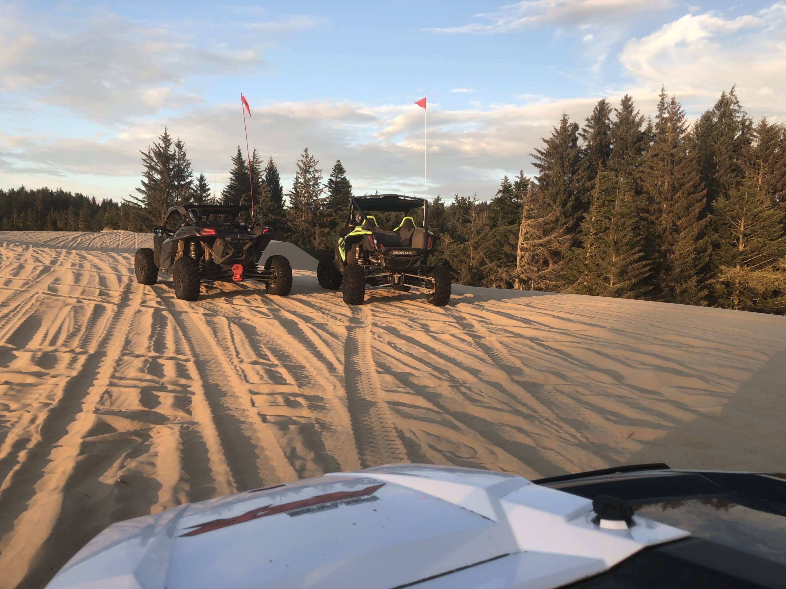 atvs making tracks in sand dune